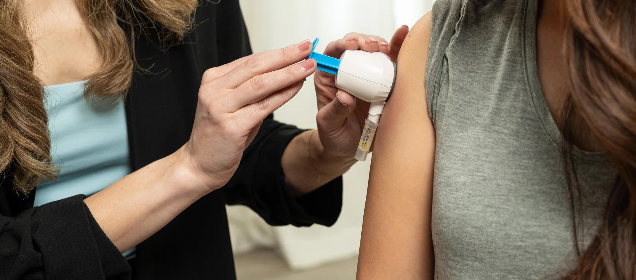 A clinician applies an upper-arm capillary collection device